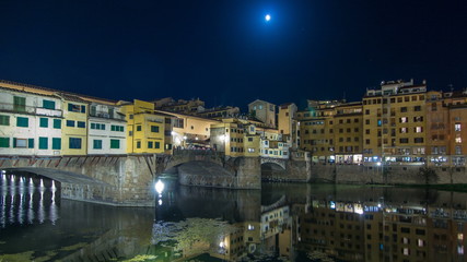 Famous Ponte Vecchio bridge timelapse  over the Arno river in Florence, Italy, lit up at night