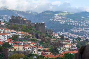 Fototapeta na wymiar Funchal town and villages upp in the mountains with São João Baptista fortres to the left
