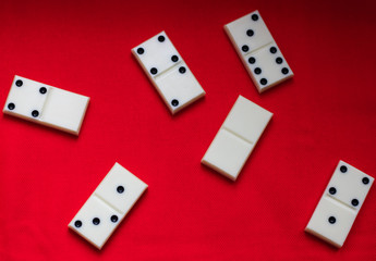  Dominoes Domino bones lie on a red fabric background.