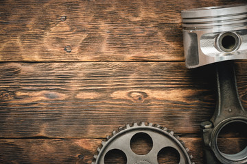 Old car spare parts on brown wooden workbench background with copy space.