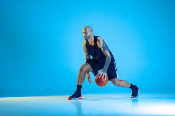 Young basketball player of team wearing sportwear training, practicing in action, motion isolated...