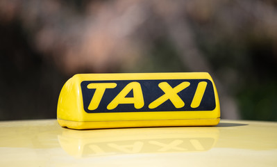 Taxi sign yellow coloe detail, defocused city street background