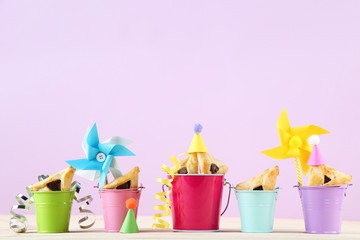 Purim holiday composition. Cookies with buckets and party supplies on pink background
