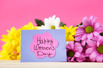 Text Happy Womens Day with chrysanthemum flowers on pink background