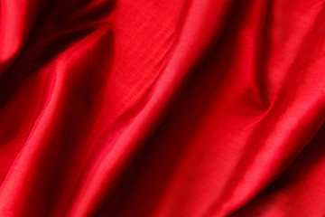 Fototapeta na wymiar Red satin fabric. Silk textile background. Wavy folds of material.