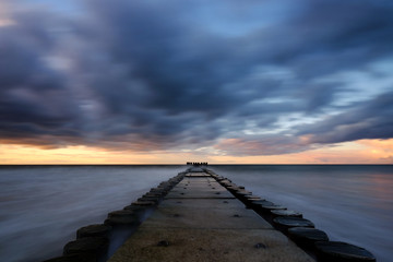 Obraz na płótnie Canvas Molo na wybrzeżu Morza Bałtyckiego o zachodzie słońca,Kołobrzeg,Polska.