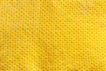 Yellow kitchen cellulose napkin closeup. Texture of hygienic tissue paper for household cleaning and wiping surfaces. Dust cleaning cloth.