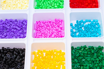 A lot of plastic toy mosaic beads sorted by color