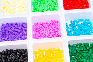A lot of plastic toy mosaic beads sorted by color