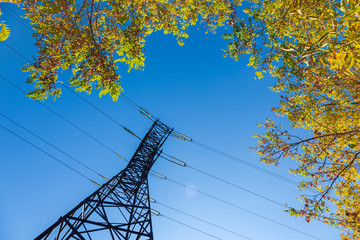 Electric transmission tower or power tower or electricity pylon and line of electric wires against a blue sky. Steel lattice tower, to support an overhead power line.