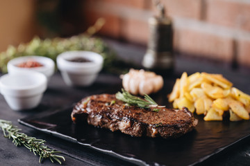 Rare filet mignon beefsteak with roasted potatoes, above view