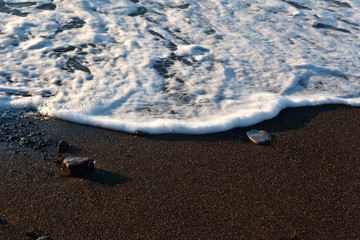 Soft ocean wave on sandy beach. Ocean wave close up with copy space for text.