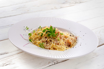 Delicious italian pasta carbonara on white wood white background.