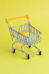 Shopping cart on yellow background