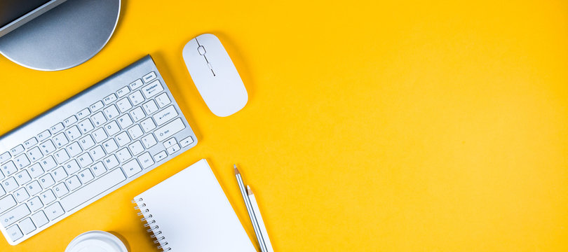 White keyboard, mouse and Notepad on yellow background. Flat lay and top view, copy space for text