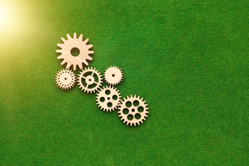 Wooden gears on a green background. The mechanism of interaction.