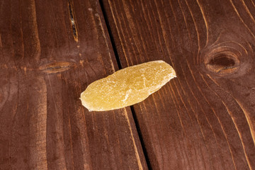 One slice of dried yellow pineapple on brown wood