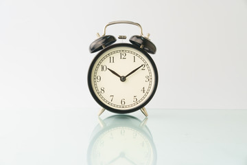 alarm clock isolated on white background with reflection. copy space. high key