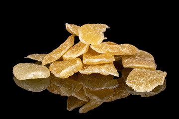 Lot of slices of dried yellow pineapple heap isolated on black glass