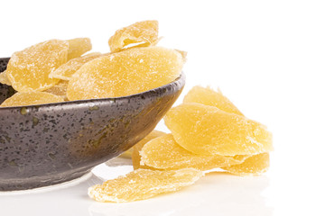 Lot of slices of sweet dried yellow pineapple in glazed bowl isolated on white background