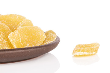 Lot of slices of dried yellow pineapple with brown ceramic coaster isolated on white background