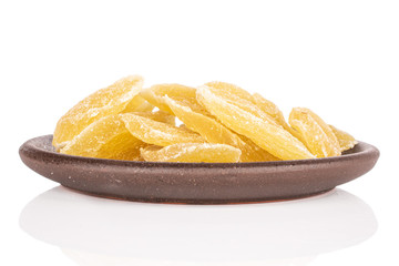Lot of slices of dried yellow pineapple with brown ceramic coaster isolated on white background