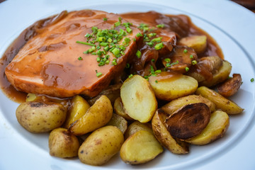 Bavarian fine meatloaf with onion sauce and roast potatoes