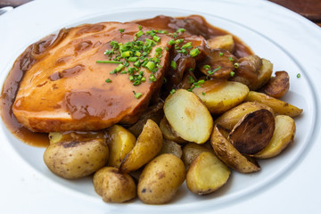 Bavarian fine meatloaf with onion sauce and roast potatoes