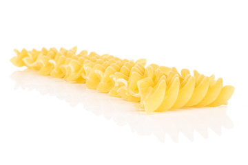 Lot of whole yellow pasta fusilli isolated on white background