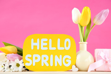 Tulip, chrysanthemum flowers with text Hello Spring and gift box on pink background