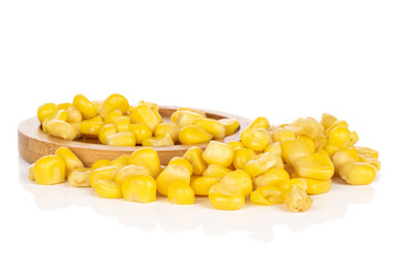 Lot of pieces of canned yellow corn on round bamboo coaster isolated on white background