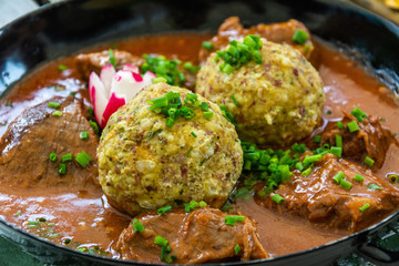Goulash stew with two Tyrolean bread dumplings, in South Tyrol, Italy.