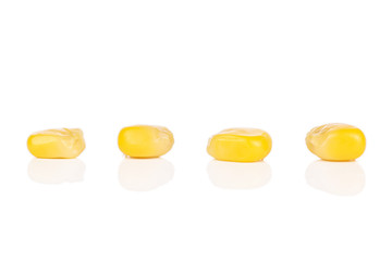 Group of four pieces of canned yellow corn isolated on white background
