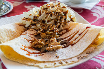 Pancakes with whipped cream, walnuts and maple syrup