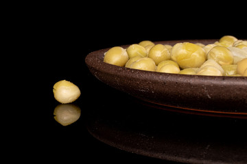 Lot of whole canned pea with brown ceramic coaster isolated on black glass
