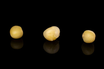 Group of three whole canned pea isolated on black glass