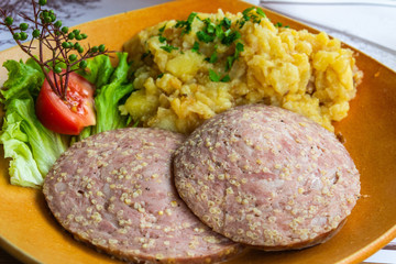 Stuffed fried sausage with potato salad in Slovenia.