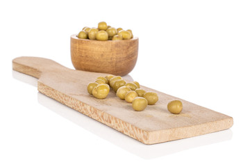Lot of whole canned pea on wooden cutting board in bamboo bowl isolated on white background
