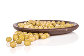 Lot of whole sweet canned pea with brown ceramic coaster isolated on white background