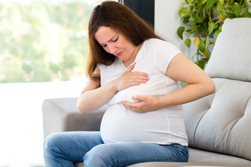 pregnant woman examining her breast