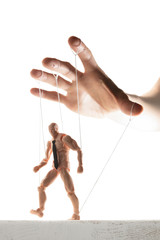 Concept of control. Marionette in human hand. Image on white.
