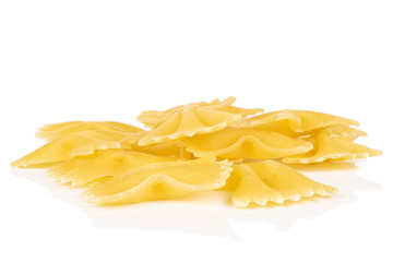Lot of whole yellow pasta farfalle heap isolated on white background