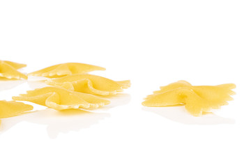 Group of six whole yellow pasta farfalle isolated on white background
