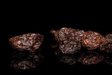 Lot of whole dried dark raisin isolated on black glass