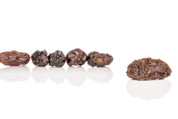 Group of six whole dried dark raisin isolated on white background