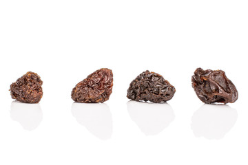 Group of four whole dried dark raisin isolated on white background