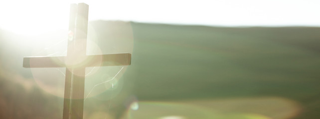 cross in nature at the sunset