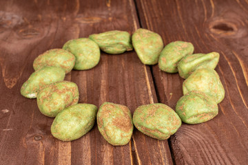 Lot of whole wasabi green peanut circle on brown wood