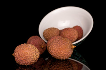 Group of six whole fresh lychee with blue chinese ceramic bowl isolated on black glass
