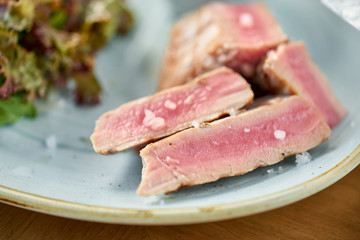 Closeup Medium rare tuna with lettuce and hot sauce. Restaurant menu